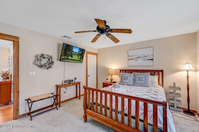 bedroom featuring a ceiling fan, light colored carpet, visible vents, and baseboards