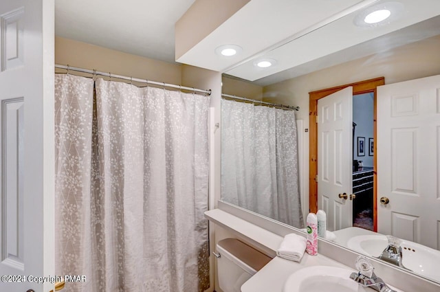 bathroom featuring toilet, vanity, and recessed lighting