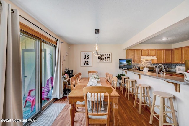 dining space featuring a textured ceiling and wood finished floors