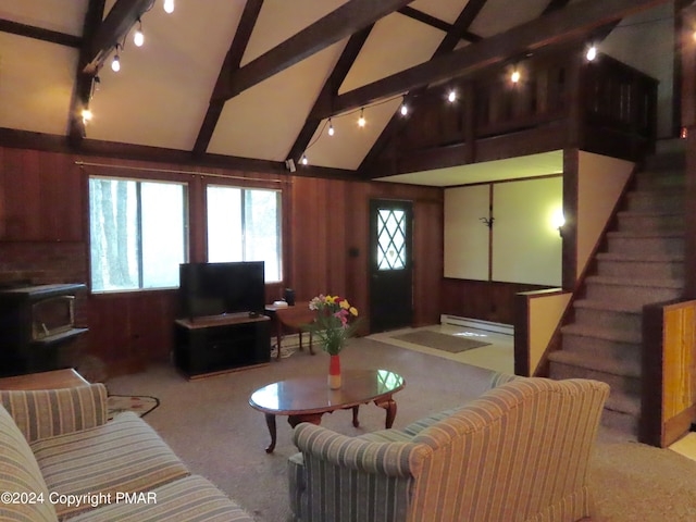 carpeted living area featuring vaulted ceiling with beams, a wood stove, stairway, and wood walls