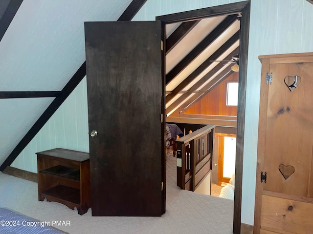 bonus room featuring lofted ceiling and wooden walls