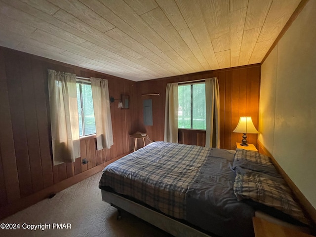 bedroom featuring wood walls, wood ceiling, and carpet