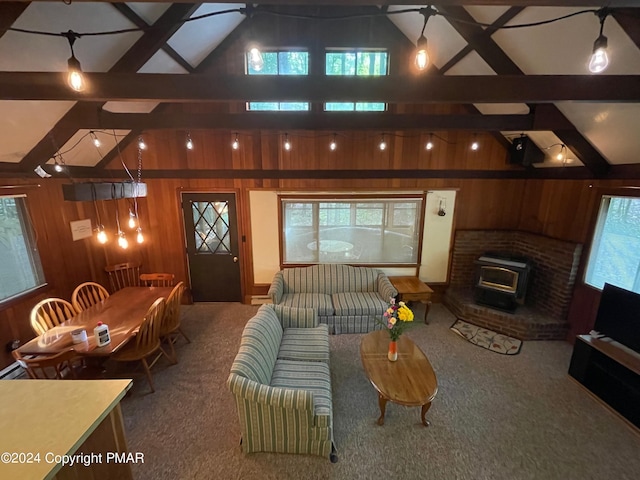 living area featuring carpet floors, vaulted ceiling with beams, and wooden walls