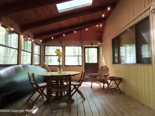 sunroom / solarium featuring lofted ceiling with skylight and wooden ceiling