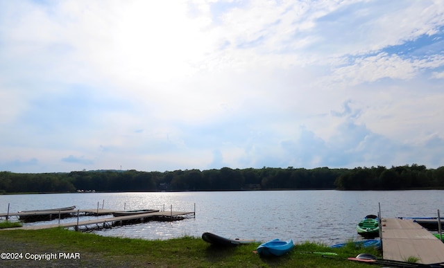 view of dock with a water view and a forest view