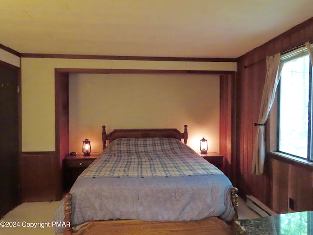 bedroom with wooden walls, multiple windows, ornamental molding, and baseboard heating