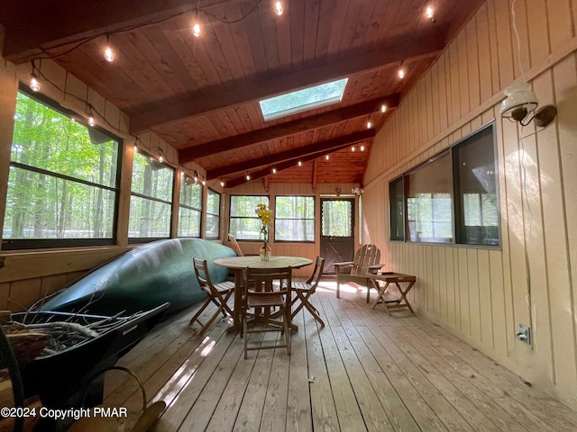 sunroom featuring vaulted ceiling with skylight and wood ceiling