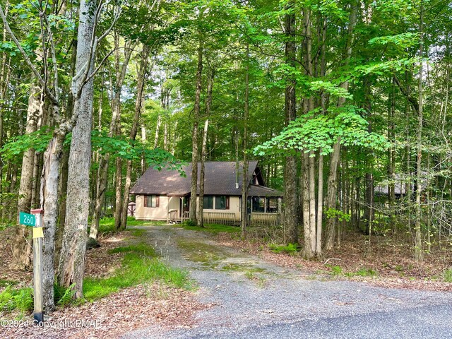260 Partridge Dr, Pocono Lake, PA 18347 - chalet / cabin with a shingled roof, driveway, and a forest view