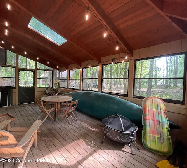 sunroom / solarium featuring lofted ceiling with skylight, wood ceiling, and rail lighting