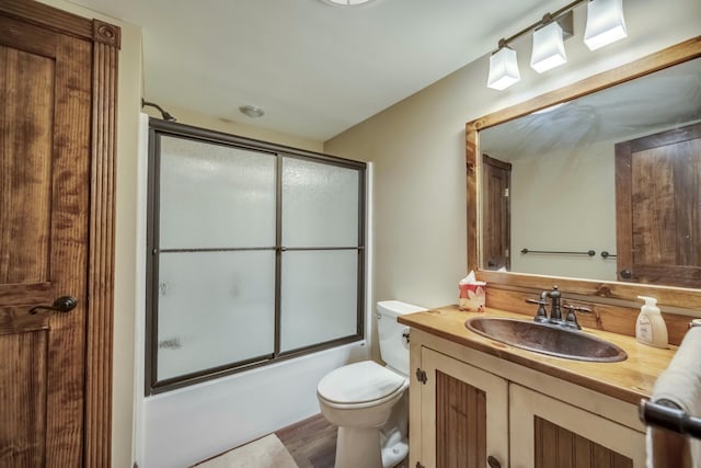 full bathroom with shower / bath combination with glass door, vanity, and toilet