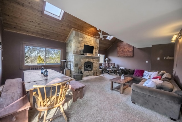 living area featuring a stone fireplace, carpet floors, wood ceiling, a ceiling fan, and lofted ceiling with skylight