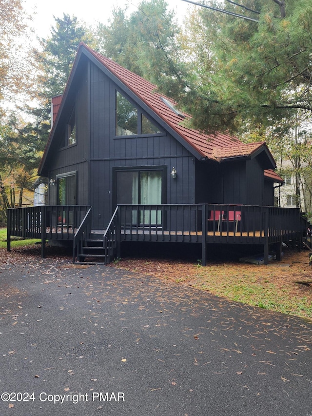 chalet / cabin with a deck and a tiled roof