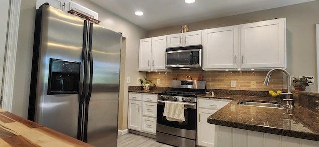 1729 Hemlock Dr, Scotrun, PA 18355 - kitchen with appliances with stainless steel finishes, a sink, white cabinetry, dark stone counters, and tasteful backsplash
