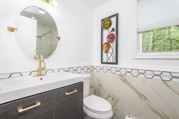 117 Clifton Dr, Bushkill, PA 18324 - bathroom featuring toilet, vanity, tile walls, and a wainscoted wall