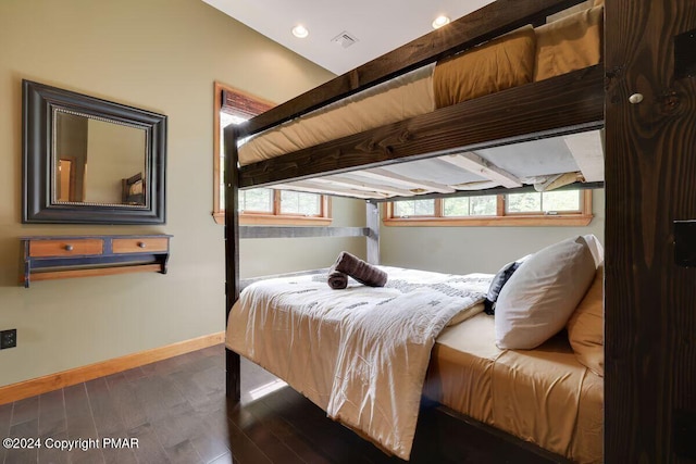 bedroom with visible vents, baseboards, and wood finished floors