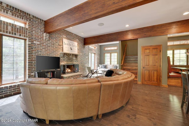 living room featuring beam ceiling, stairway, a wealth of natural light, and wood finished floors