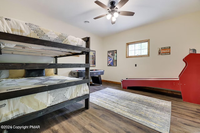 bedroom featuring baseboards, visible vents, and wood finished floors