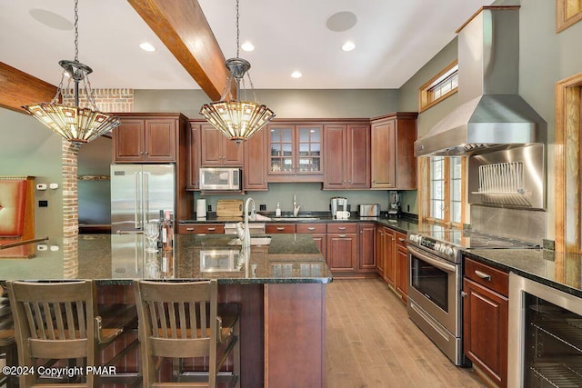 kitchen featuring wall chimney exhaust hood, beverage cooler, stainless steel appliances, and a notable chandelier