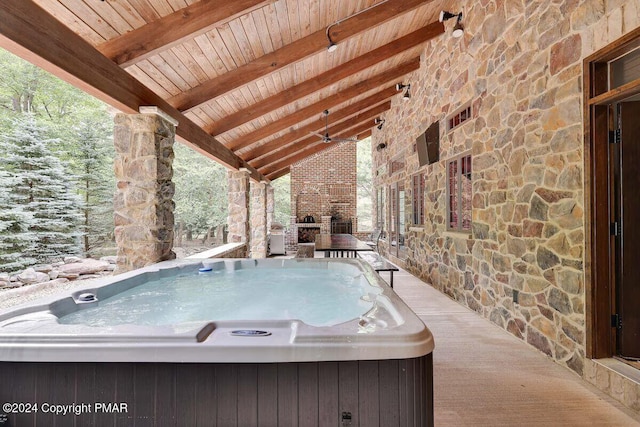 view of patio featuring a hot tub and a fireplace