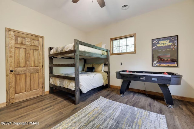 bedroom with a ceiling fan, wood finished floors, visible vents, and baseboards