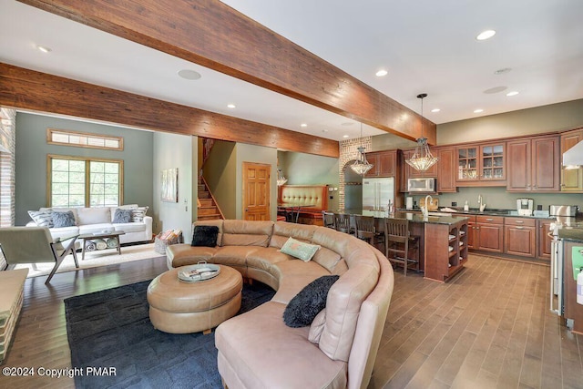 living area featuring light wood-type flooring, stairway, beamed ceiling, and recessed lighting