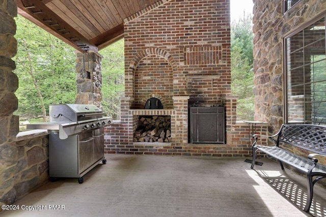 view of patio featuring an outdoor brick fireplace, grilling area, and an outdoor kitchen