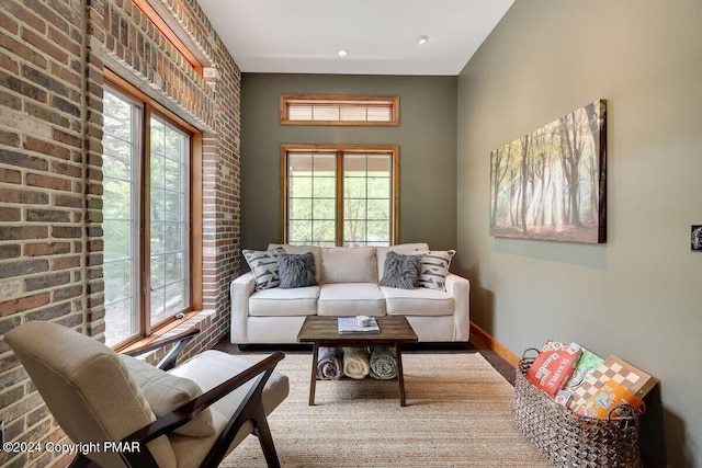 living room with baseboards and brick wall