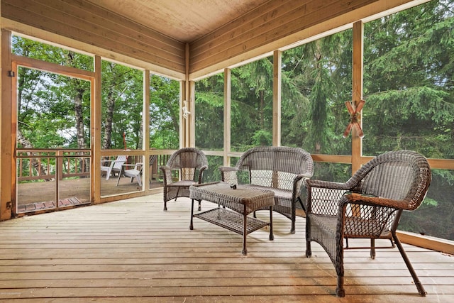 sunroom featuring plenty of natural light and a view of trees