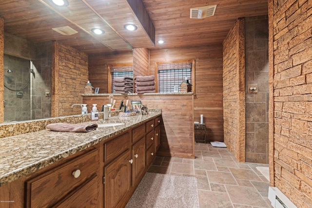 bathroom featuring visible vents, tiled shower, wooden ceiling, stone tile flooring, and a baseboard heating unit