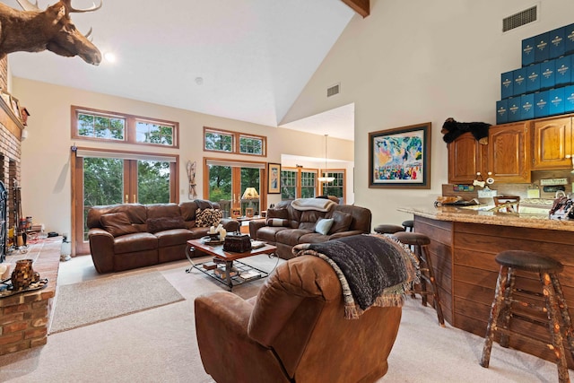 living area with light carpet, high vaulted ceiling, visible vents, and beam ceiling