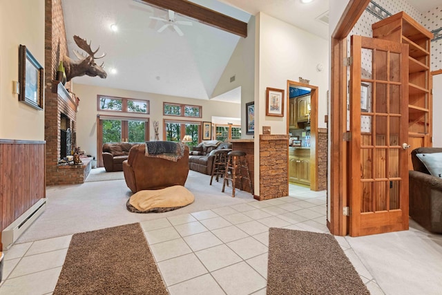 living area featuring high vaulted ceiling, a baseboard radiator, light colored carpet, a large fireplace, and wainscoting