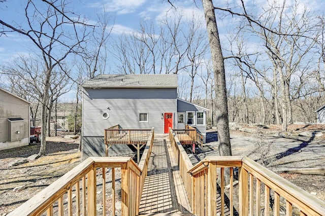 back of property featuring a deck and roof with shingles