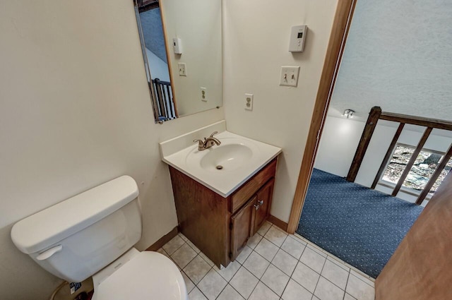 half bathroom featuring vanity, toilet, and tile patterned flooring