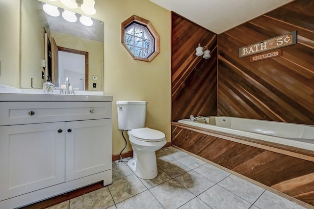 full bathroom with baseboards, toilet, a bath, tile patterned floors, and vanity