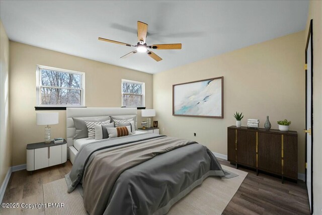 bedroom featuring ceiling fan, wood finished floors, and baseboards