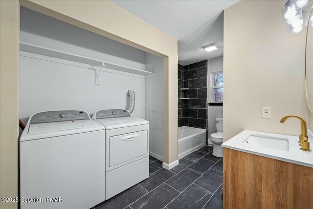 clothes washing area featuring laundry area, a sink, and washer and dryer