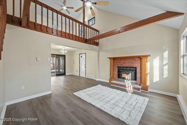 unfurnished living room featuring dark wood-style flooring, baseboard heating, and baseboards