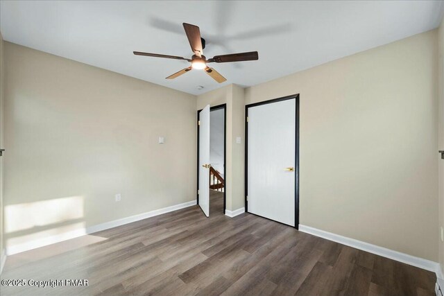 unfurnished bedroom featuring a ceiling fan, baseboards, and wood finished floors