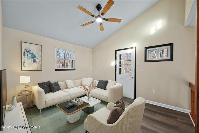 living room with a ceiling fan, vaulted ceiling, baseboards, and wood finished floors