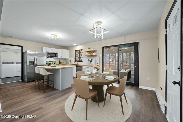 dining area featuring baseboards, dark wood finished floors, and independent washer and dryer