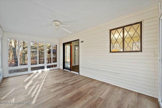 unfurnished sunroom with a ceiling fan