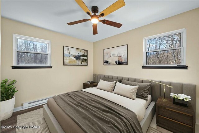 bedroom featuring a baseboard heating unit, wood finished floors, a ceiling fan, and baseboards