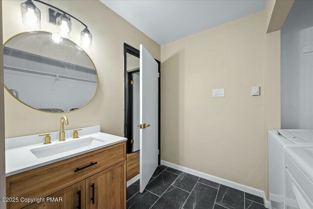 bathroom with marble finish floor, washer and clothes dryer, baseboards, and vanity