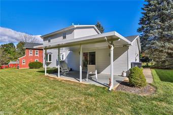 rear view of property featuring a patio area and a yard