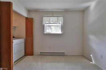 washroom with a baseboard heating unit and washer / dryer