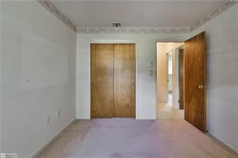 unfurnished bedroom with carpet and a closet