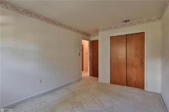 unfurnished bedroom with a closet and visible vents