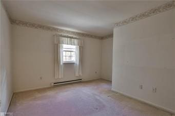 spare room with a baseboard radiator, carpet flooring, and baseboards