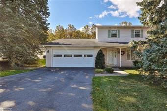 traditional-style home with aphalt driveway, a front lawn, and an attached garage