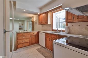 kitchen featuring brown cabinets, white dishwasher, backsplash, and light tile patterned floors